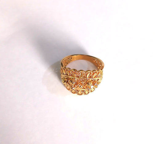 Gold ring with intricate design on a white background